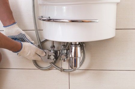 Closeup man fixing sink in a bathroom.の写真素材