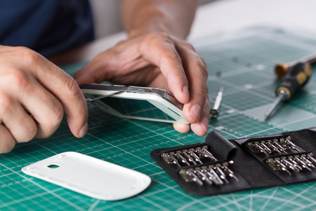 Man repairing broken smartphone, close up photo.の写真素材