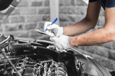 Auto mechanic checking car engine at the garage.の写真素材