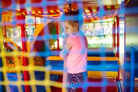 Cute little girl have fun at soft outdoor playground.の写真素材