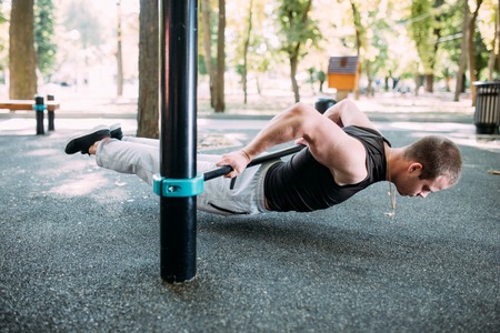 Healthy handsome active man with fit muscular body doing workout exercises.