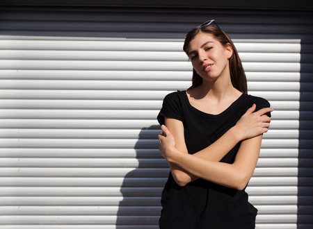 Portrait of girl in rock black style, standing outdoors in the city against the silver metal urban wall.の写真素材