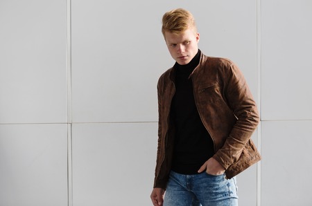 Young handsome stylish man in brown jacket in autumn time outdoor in casual style.の写真素材