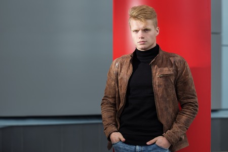 Young handsome stylish man in brown jacket in autumn time outdoor in casual style.の写真素材