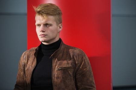 Young handsome stylish man in brown jacket in autumn time outdoor in casual style.の写真素材