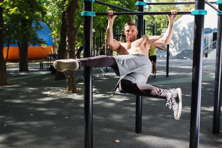 Healthy handsome active man with fit muscular body doing workout exercises.
