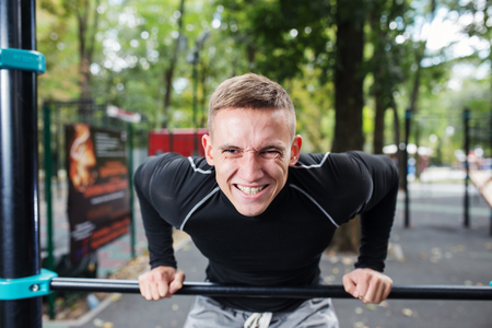 Healthy handsome active man with fit muscular body doing workout exercises.