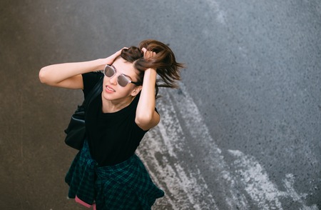 Brunette girl in rock black style, standing outdoors in the city street.の写真素材