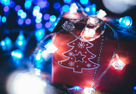 Christmas gift boxes with glowing garland and blue bokeh lightsの写真素材