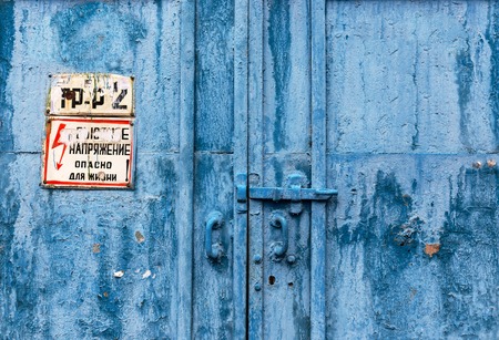 Big industrial metal door with rusty cracked paintの写真素材