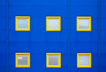 Facade of a modern blue warehouse and six yellow windowsの写真素材