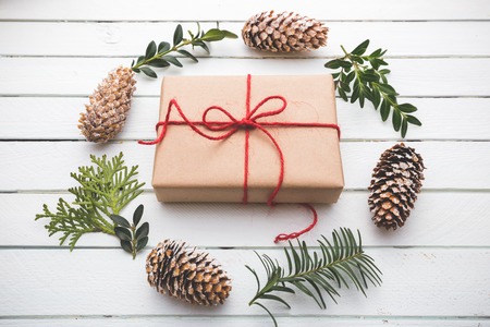 Homemade wrapped rustic brown paper packages with various natural things on white wooden surfaceの写真素材
