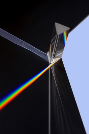 Prism splitting white light into a spectrum on a black backgroundの写真素材