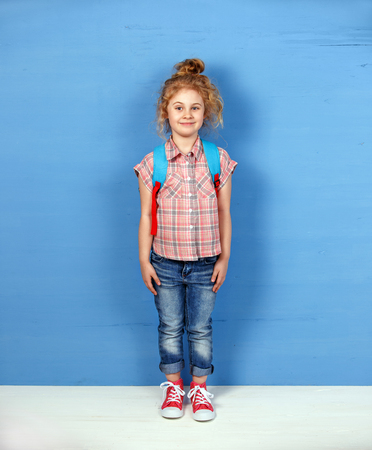 Happy child girl tourist standing at the blue wall. Travel and adventure conceptの写真素材