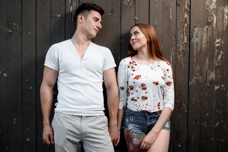 Portrait of young modern couple in love, posing outdoors in city streetの写真素材