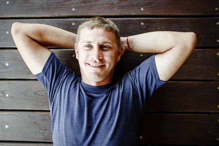 Young man lying and relaxing on wooden deck outdoor.の写真素材