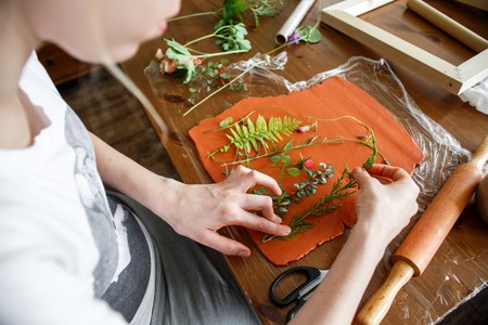 Woman making botanical plaster artwork in her home studio.