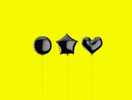 Three black metallized foil balloons on a yellow background. 3d render illustrationの写真素材