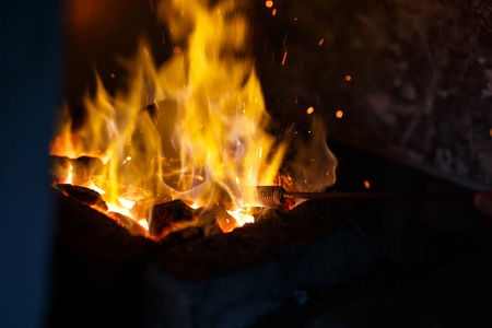 Hot metal in the fire before being hammered by a blacksmithの写真素材