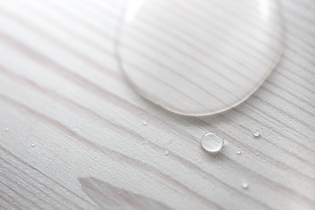Water drops on white wooden surface made from larch wood covering by oil with wax.の写真素材