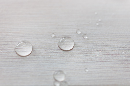 Water drops on white wooden surface made from larch wood covering by oil with wax.の写真素材