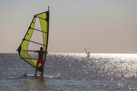 Windsurfers in the sea during sunset, active lifestyleの写真素材