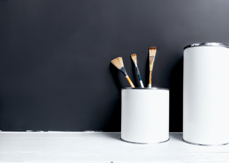 The paint cans with paintbrushes next to black wall. Home renovation. Generative AIの素材