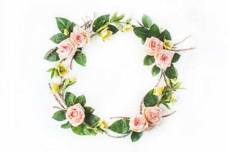 round frame wreath with pink roses, yellow flowers, branches, leaves and petals isolated on white background. flat lay, overhead viewの写真素材
