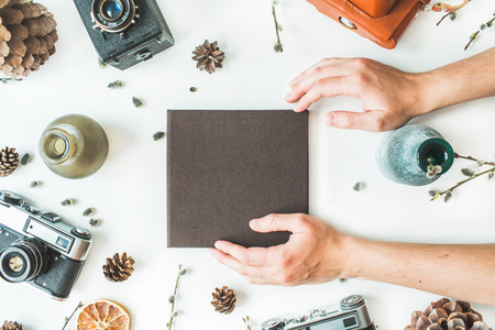 black wedding or family photo album, hands, cones, vintage old-fashioned camera, candlesticks,...