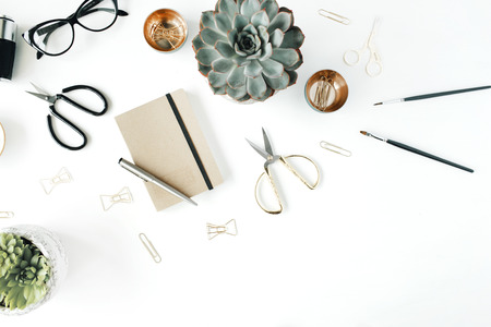 feminini desk workspace with succulent, retro camera, scissors, diary, glasses and golden clips on white background. flat lay, top viewの写真素材
