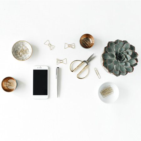 feminini desk workspace with succulent, phone, scissors and golden clips on white background. flat...