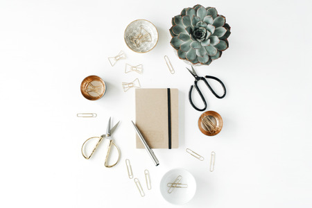 feminini desk workspace with succulent, scissors, diary and golden clips on white background. flat lay, top viewの写真素材