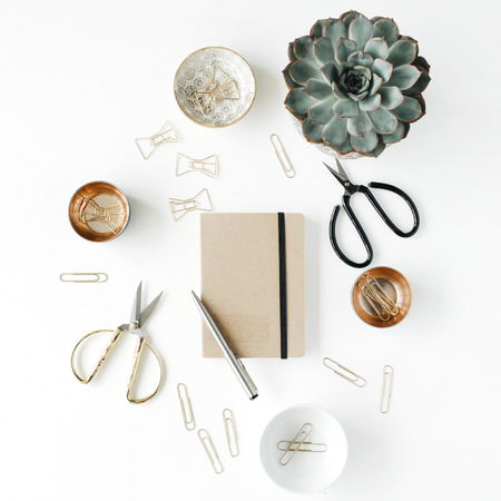 feminini desk workspace with succulent, scissors, diary and golden clips on white background. flat lay, top viewの写真素材