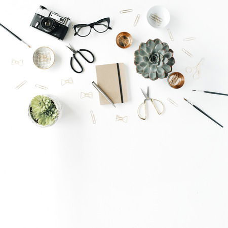 feminini desk workspace with succulent, retro camera, scissors, diary, glasses and golden clips on white background. flat lay, top viewの写真素材