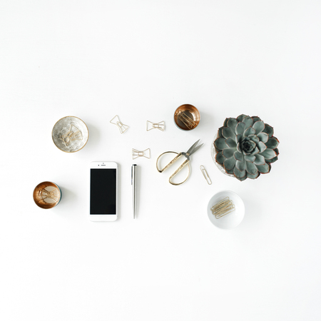 feminini desk workspace with succulent, phone, scissors and golden clips on white background. flat lay, top viewの写真素材