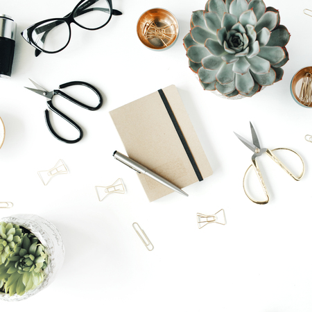 feminini desk workspace with succulent, retro camera, scissors, diary, glasses and golden clips on white background. flat lay, top viewの写真素材