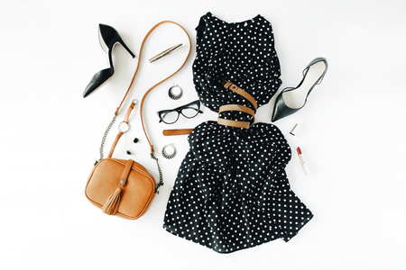 flat lay feminini clothes and accessories collage with black dress, glasses, high heel shoes, purse, watch, mascara, lipstick, earrings on white background.の写真素材