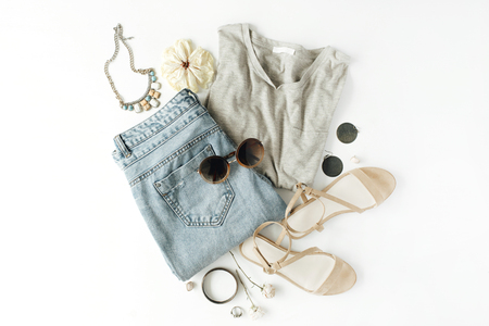 flat lay feminine clothes and accessories collage with shirt, jeans shorts, sunglasses, bracelet, sandals, earrings on white background.の写真素材