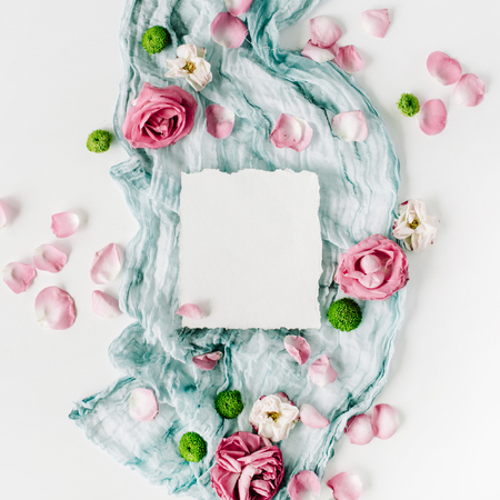 clean paper blank with red roses, pink petals and blue textile on white background. Flat lay, top viewの写真素材