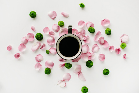 Colorful bright image made of leaves, roses and petals with coffee cup on white. flat lay, top viewの写真素材