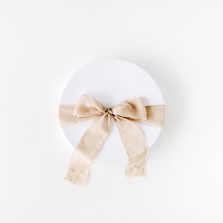 white gift cardboard box with brown bow on white background. flat lat, top viewの写真素材