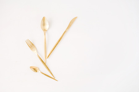 golden fork, spoon, knife isolated on white. flat lay, top viewの写真素材