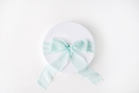 white gift cardboard box with blue bow on white background. flat lat, top viewの写真素材