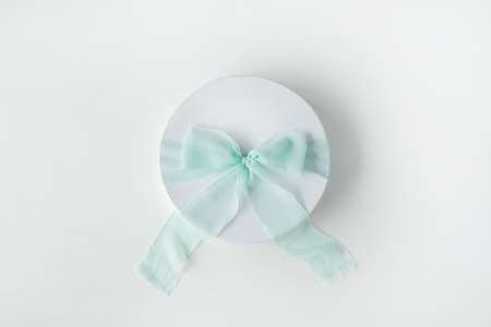 white gift cardboard box with blue bow on white background. flat lat, top viewの写真素材
