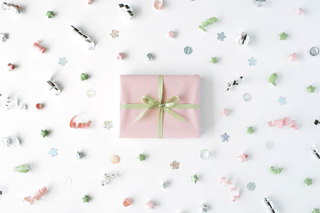 pink gift box with ribbon and bow on white decorated with tinsel background. flat lat, top viewの写真素材