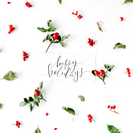 words happy holidays and minimal creative berry arrangement pattern on white. flat lay, top view. christmas background wallpaper.の写真素材