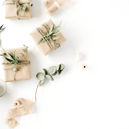 creative arrangement pattern of craft boxes and green branches on white background. flat lay, top viewの写真素材