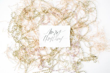 calligraphy words merry christmas and christmas tinsel decoration. flat lay, top viewの写真素材
