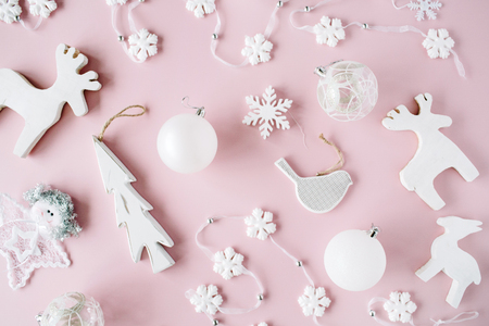 pattern made of white christmas decoration with christmas glass balls, tinsel, bow, elk, bird on pink background. christmas wallpaper. flat lay, top viewの写真素材