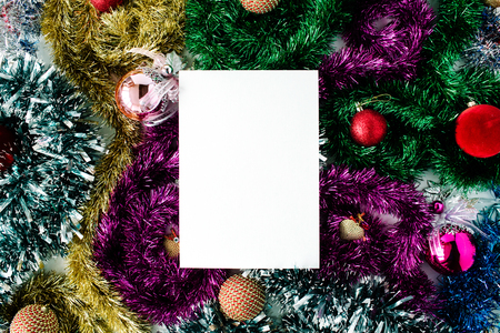 empty paper blank and christmas decoration with colored glass balls, tinsel, toys. flat lay, top viewの写真素材